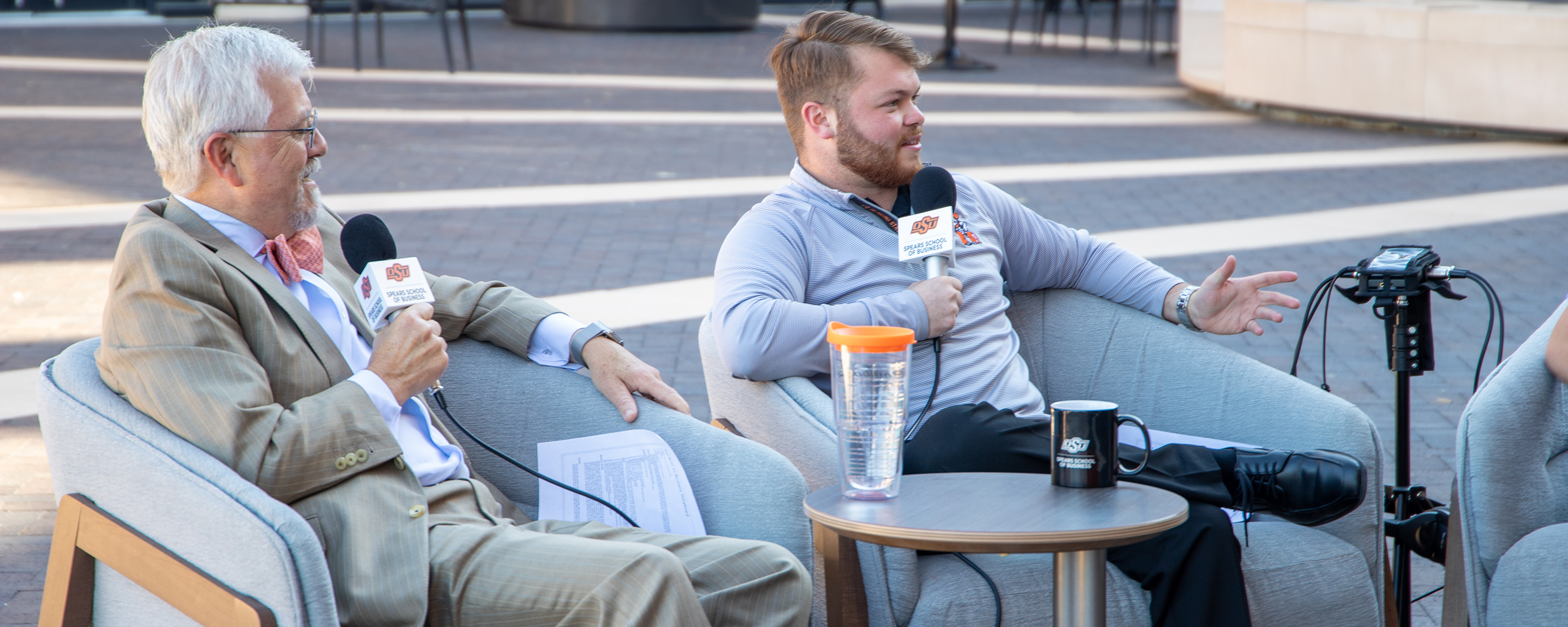 Dean Ken Eastman and Dalton Wolf interview students in the Business Plaza for the Buzz on Business podcast. 