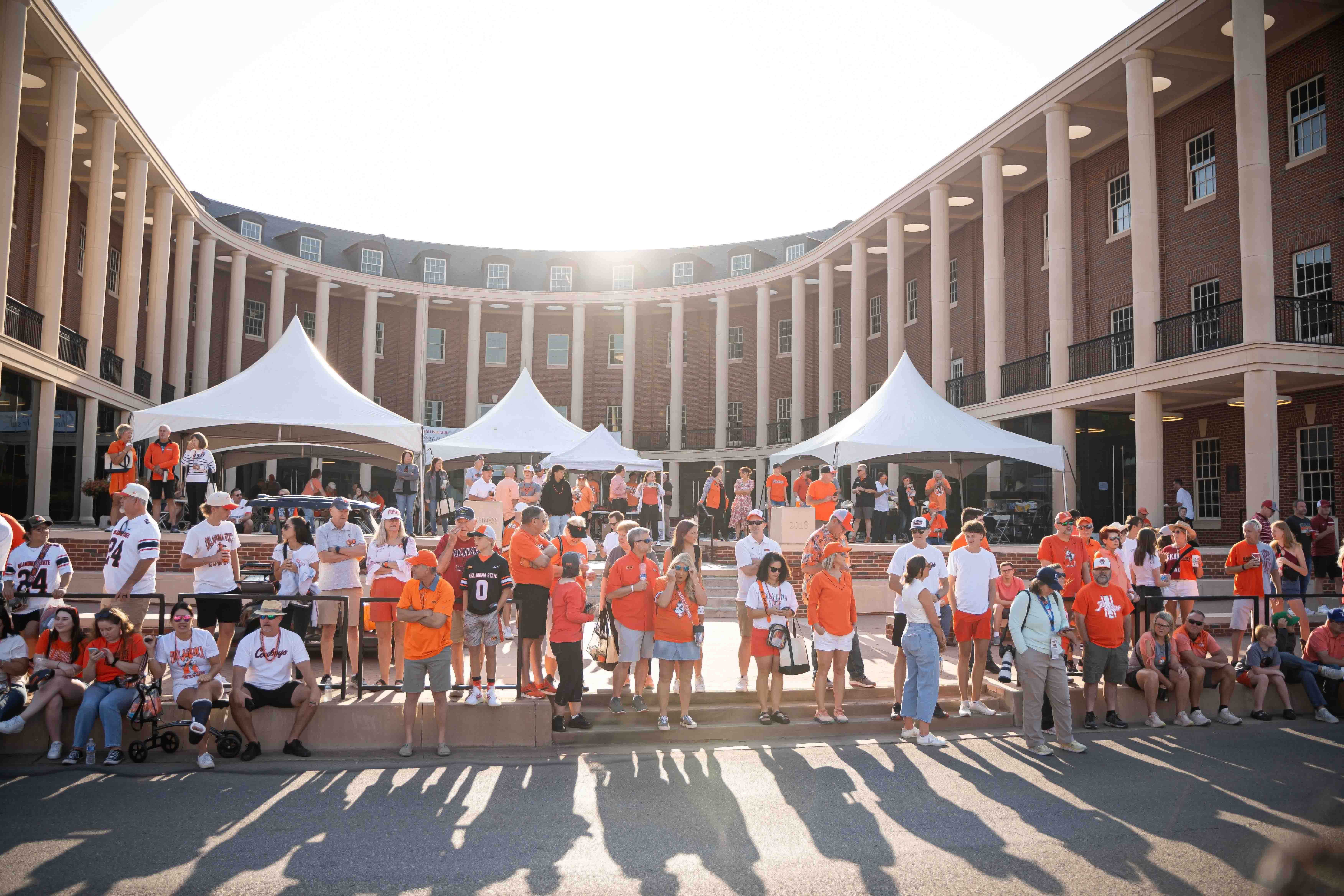 Lots of people dressed up in OSU colors outside of the Business Building before the football game.