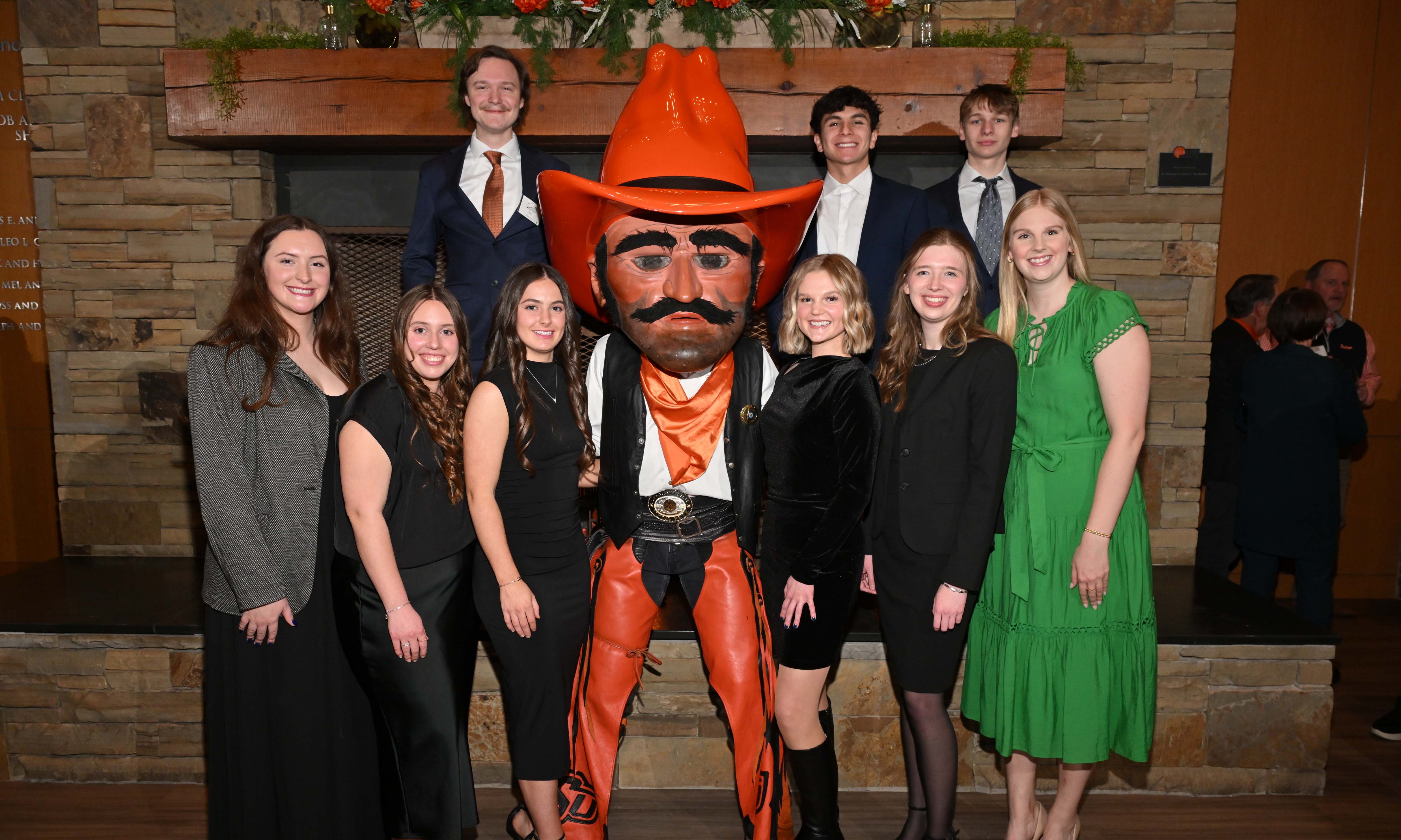 Group of students in formal attire posing with the Pistol Pete mascot. Group of students in formal attire posing with the Pistol Pete mascot.