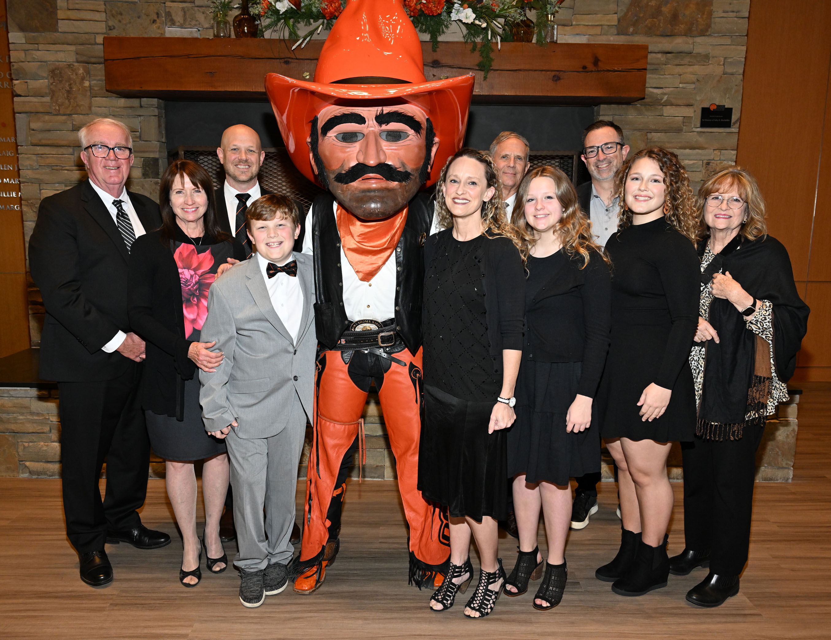 Award winner's large family smiling with Pistol Pete in alumni center lobby. Award winner's large family smiling with Pistol Pete in alumni center lobby.
