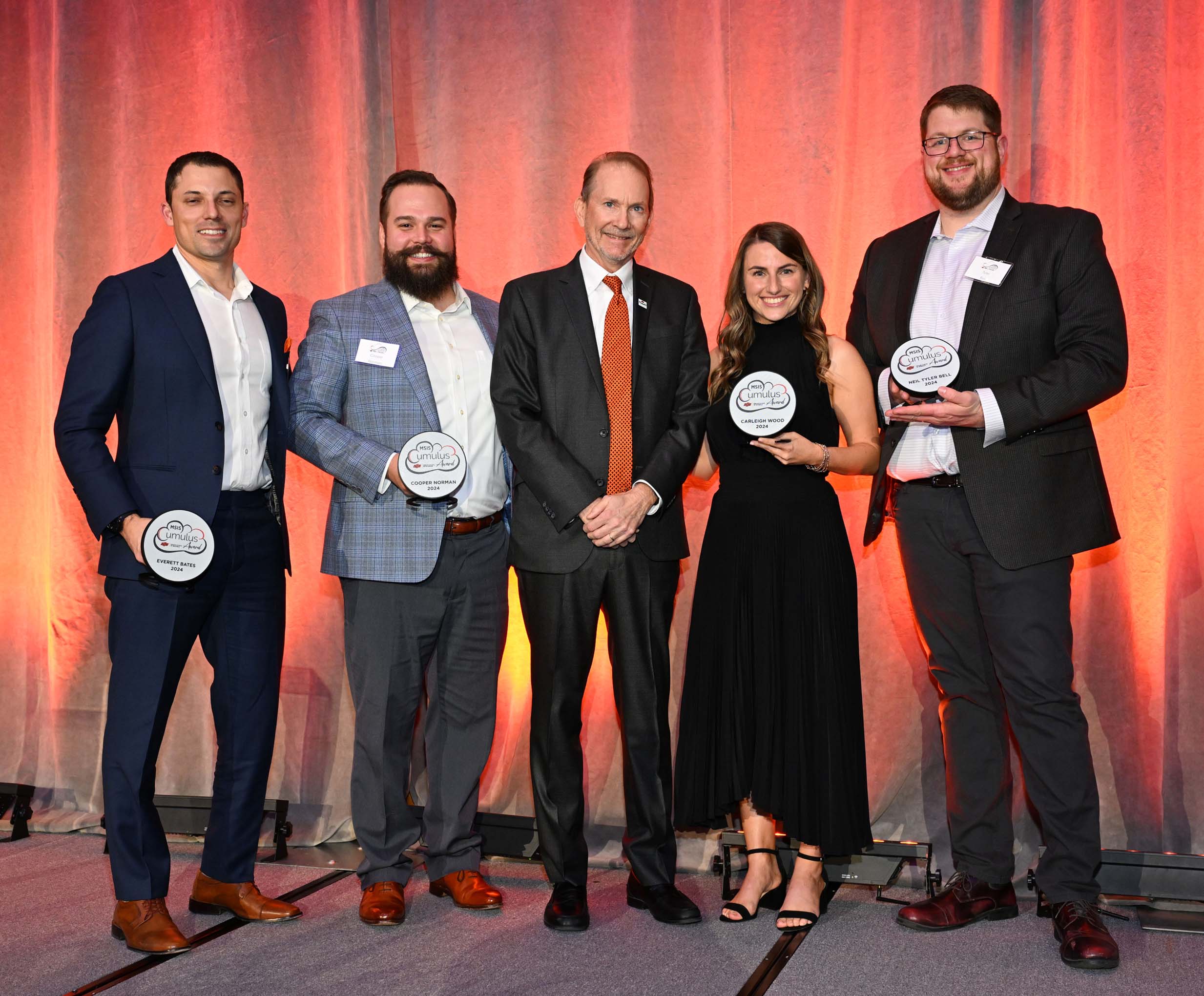 Cumulus award winners standing on stage holding awards. Cumulus award winners standing on stage holding awards.