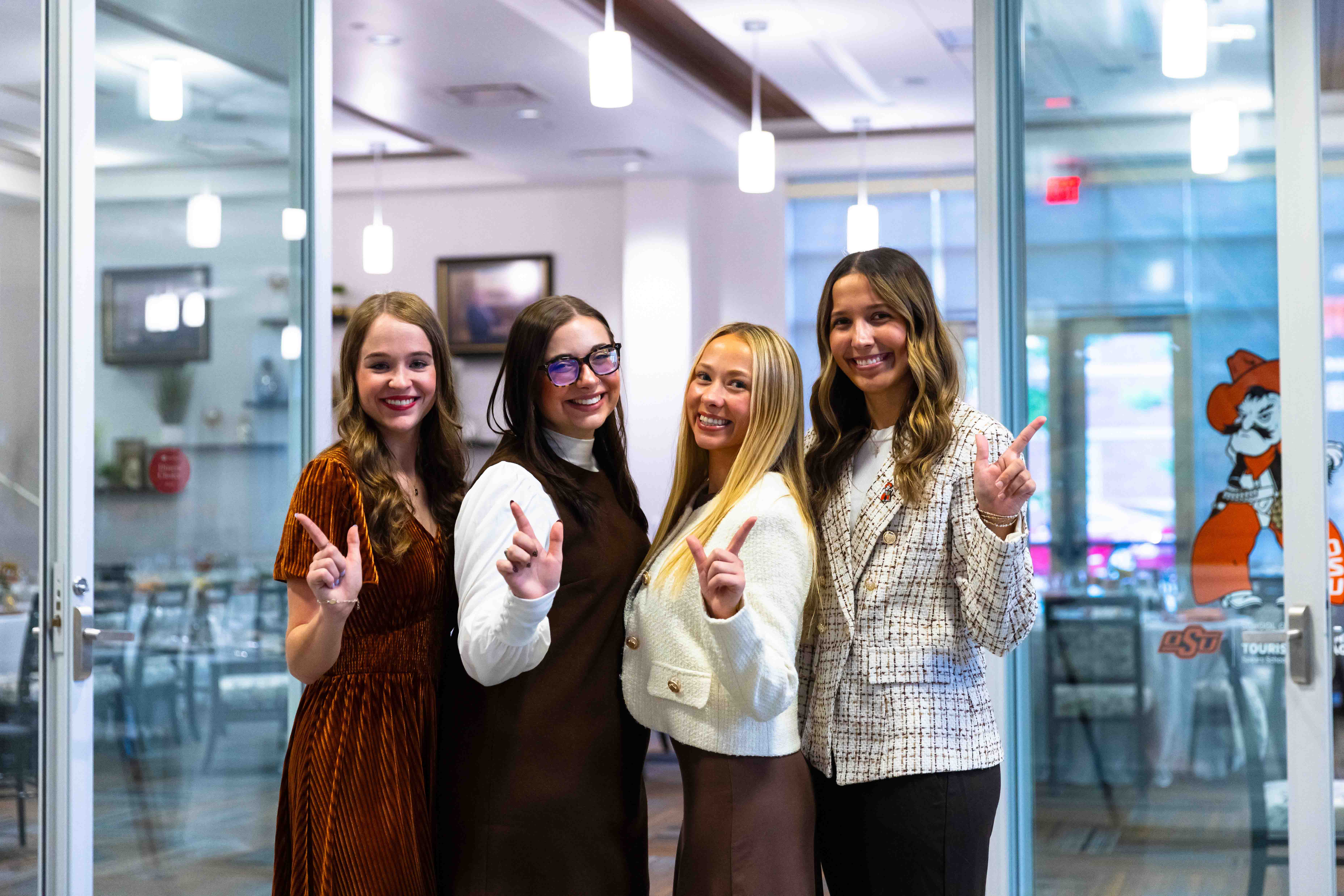 Female students dressed professionally hold up a 