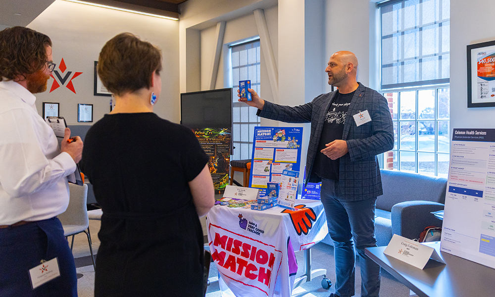 A VEP participant holds a Mission Match box in front of the judges.
